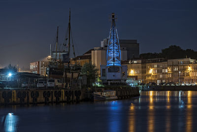 River with built structures against sky at night