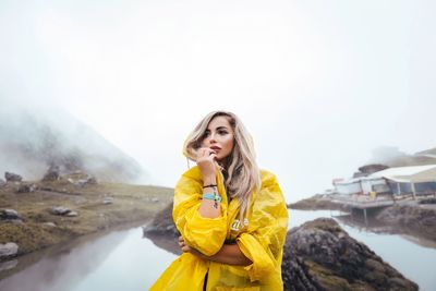 Young woman standing on mountain against sky