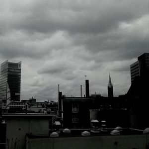 View of cityscape against cloudy sky