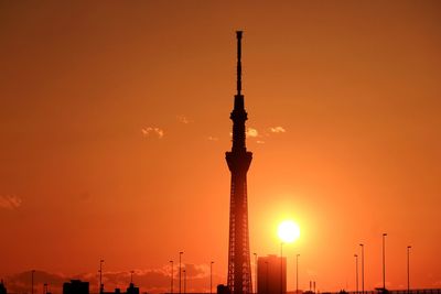 Low angle view of silhouette tokyo sky tree against orange sky during sunset