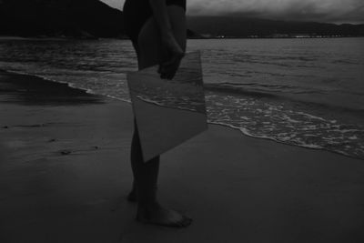 Low section of woman standing on beach