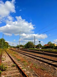 Railroad tracks on field against sky