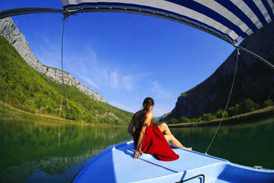 Woman on boat in lake against sky