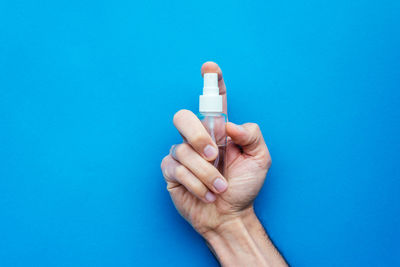 Close-up of human hand against blue background