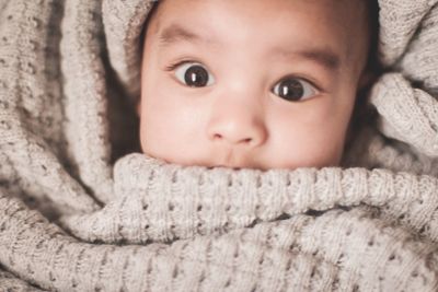 Portrait of cute baby boy wrapped in blanket