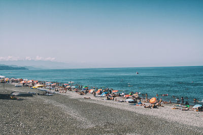 Group of people on beach against sky in city