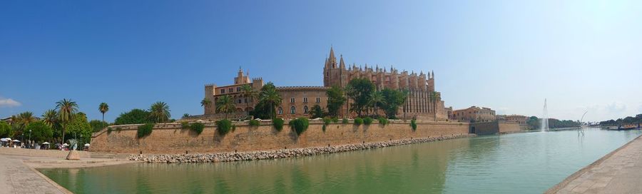 View of buildings by canal against sky
