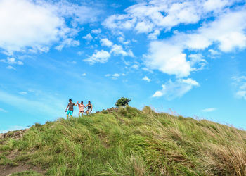 People standing on landscape against sky