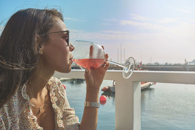 Beautiful young girl hand holding cup wine the beginning of summer, summer concept