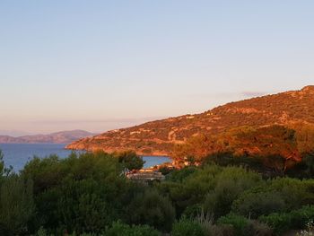 Scenic view of sea and mountains against clear sky