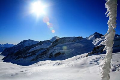 Scenic view of snow mountains against blue sky