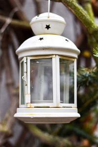 Close-up of lantern hanging against window