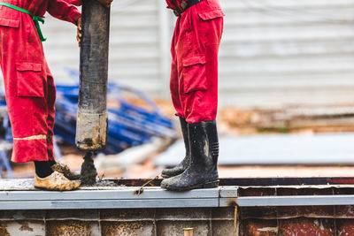 Low section of men working on metal