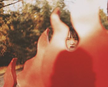 Portrait of young woman with red built structure in foreground outdoors