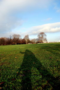 Scenic view of grassy field against cloudy sky