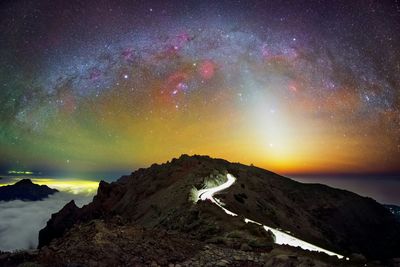 Scenic view of mountains against sky at night