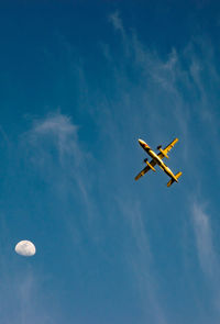 Low angle view of airplane against blue sky