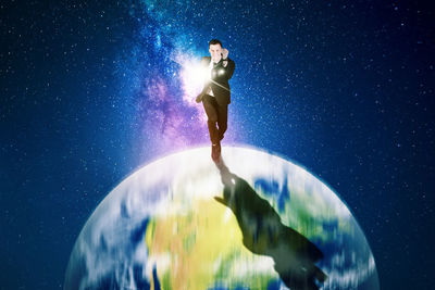 Low angle view of woman standing against blue sky