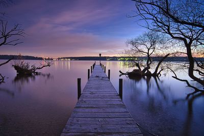 Pier over lake against sky during sunset