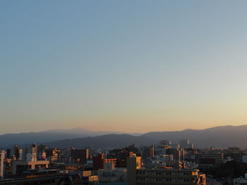 Cityscape against clear sky during sunset