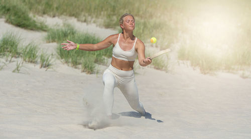 Full length of woman with arms raised standing on land