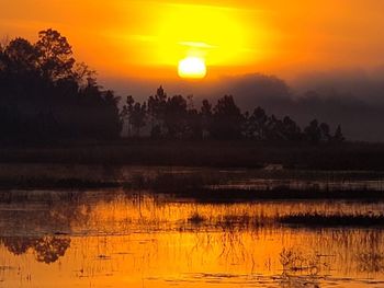 Scenic view of lake against orange sky