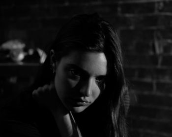 Close-up of sad thoughtful young woman in darkroom