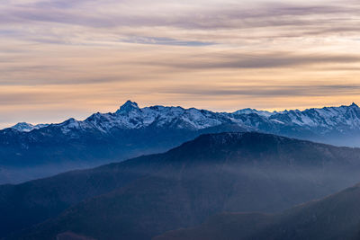 Scenic view of snowcapped mountains against sky during sunset