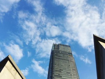 Low angle view of modern building against cloudy sky