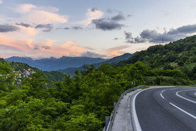 Road leading towards mountains against sky