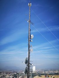 Low angle view of communications tower against blue sky