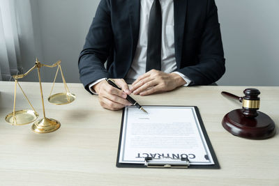 Midsection of lawyer working at table