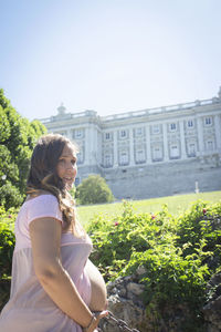 Side view of woman standing against plants