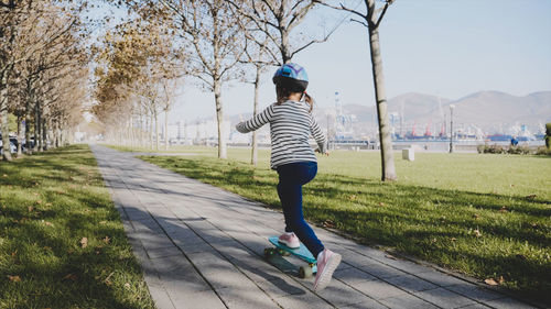 Rear view of woman walking on footpath in park