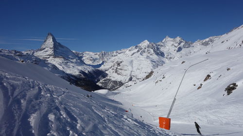 Scenic view of snowcapped mountains against clear blue sky