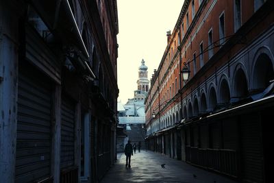 People walking in city against sky