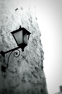 Low angle view of electric lamp against sky