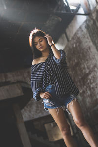 Young woman standing in abandoned building