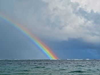 Scenic view of rainbow over sea against sky