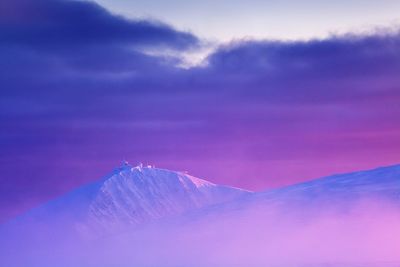 Scenic view of snowcapped mountains against sky during sunset