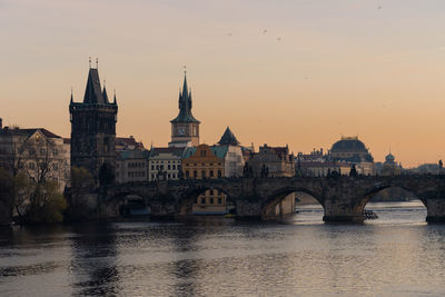 Scenic view of charles bridge over river vltava in prague. national theater building  in background