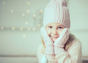 Portrait of smiling girl sitting at home during winter