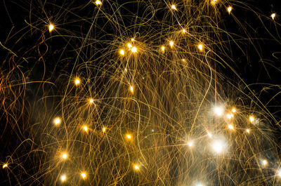 Close-up of illuminated firework display against sky at night