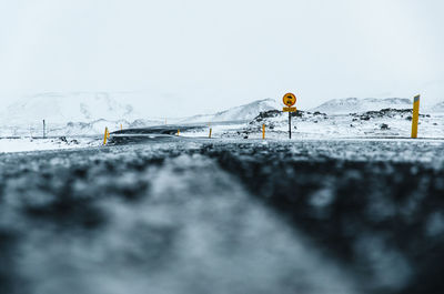 Close-up of snow on road against sky. 