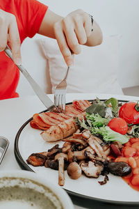 Midsection of woman eating food at restaurant