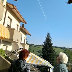 Rear view of people on building against sky