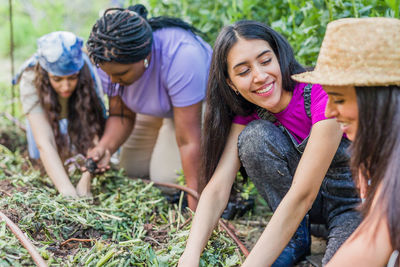 Smiling woman enjoying harvesting vegetable at garden