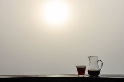 Wine glass on table against sky