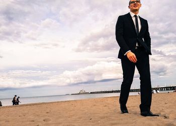 Low angle view of businessman walking at beach