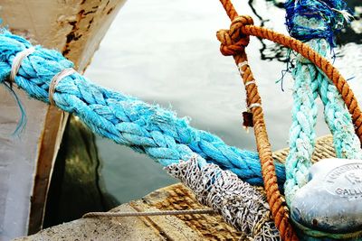 Close-up of rope tied to boat moored at pier